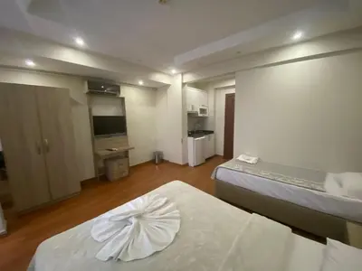 a hotel room with two beds and a flat screen tv at Birinci Apart Hotel in Istanbul