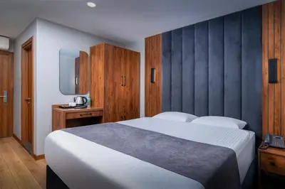 a bedroom with a large white bed and wooden cabinets at Elite Port Hotel Istanbul Airport in Arnavutköy