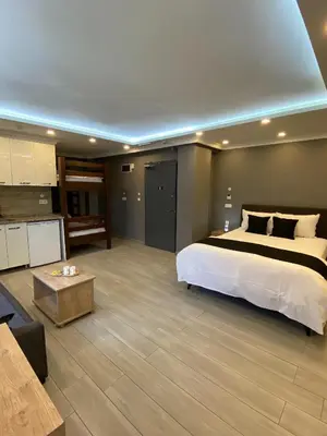 a bedroom with a large bed and a living room at Sahra Kent Otel Kadıköy in Istanbul