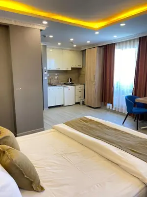 a large bed in a room with a kitchen at Sahra Kent Otel Kadıköy in Istanbul