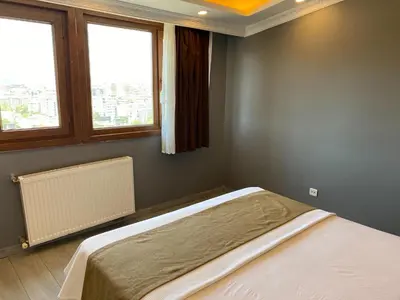 a bedroom with a bed and two windows at Sahra Kent Otel Kadıköy in Istanbul