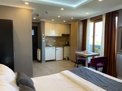 a bedroom with a bed and a kitchen with a table at Sahra Kent Otel Kadıköy in Istanbul
