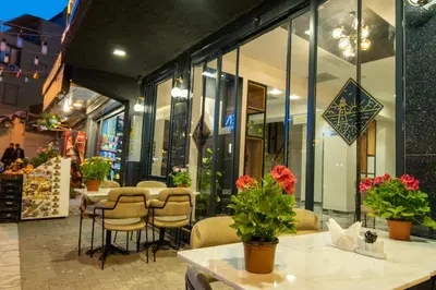 a restaurant with tables and chairs in front of a store at Linda Port Hotel in Istanbul