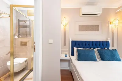 a bedroom with a blue bed and a bathroom at Begonville Corner in Istanbul