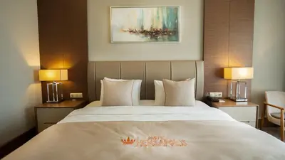 a bedroom with a large white bed with two lamps at Motel Heksapolis in Tavşancıl