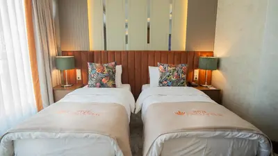 two beds in a hotel room with two lamps at Motel Heksapolis in Tavşancıl