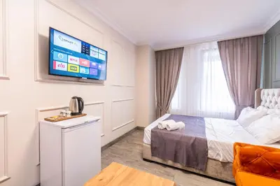 a hotel room with a bed and a flat screen tv at The Royal Luxury Hotels in Istanbul