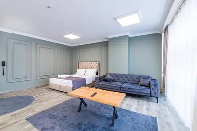 a bedroom with a bed and a couch and a table at The Royal Luxury Hotels in Istanbul