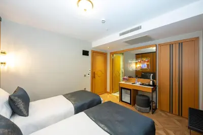 a hotel room with two beds and a desk at Freya Hotel in Istanbul