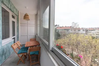 a balcony with two chairs and a table and a window at 2BR Bright Kadıköy Apartment & AC in Every Room in Istanbul