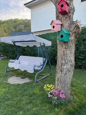 a swing with birdhouses on a tree in a yard at Sapanca Villa Dereiçi in Sapanca
