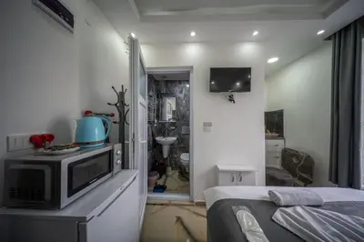 a small room with a bed and a microwave at Amida Family apart in Istanbul