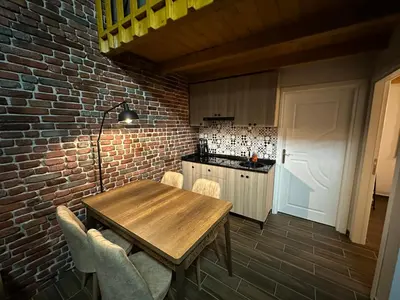 a kitchen with a wooden table and a brick wall at ROSE SAPANCA STONE HOUSE in Sakarya