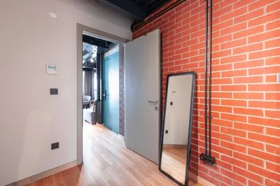 a room with a brick wall and a mirror at Homie Suites - ''Loft 27'' Urban Comfort Suites in the Heart of Cihangir in Istanbul
