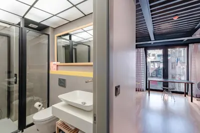 a bathroom with a sink and a toilet and a window at Homie Suites - ''Loft 27'' Urban Comfort Suites in the Heart of Cihangir in Istanbul