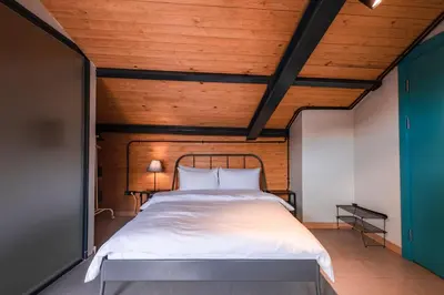 a bed in a room with a wooden ceiling at Homie Suites - ''Loft 27'' Urban Comfort Suites in the Heart of Cihangir in Istanbul