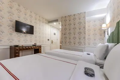 a hotel room with two beds and a flat screen tv at Khai Karaköy in Istanbul