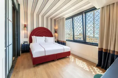 a bedroom with a bed with a red headboard and windows at Khai Karaköy in Istanbul