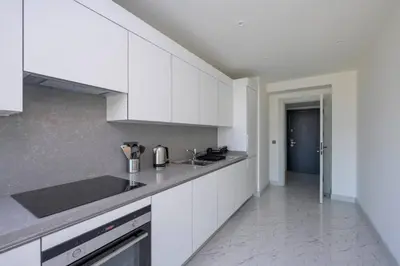 a kitchen with white cabinets and a counter top at Gorgeous Corner Deluxe 1BD CondoPoolViews! #133 in Istanbul