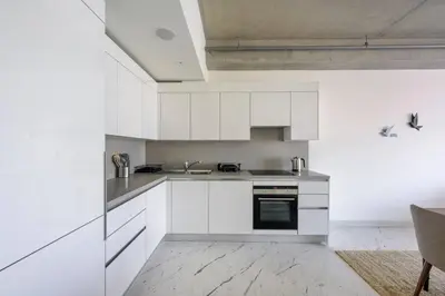 a kitchen with white cabinets and a sink at Bright Lovely Deluxe 1BD CondoPoolViews! #134 in Istanbul