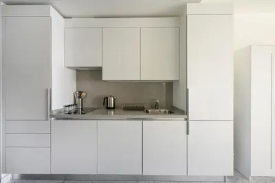 a white kitchen with white cabinets and a sink at Gorgeous Bright Studio Parking PoolViews! #135 in Istanbul