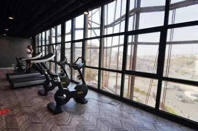 a gym with two exercise bikes in a room with windows at Gorgeous Modern 1BD TerracePoolViews! #183 in Istanbul