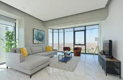 a living room with a couch and a tv at Cool Airy Modern 2bd2bath Parkingpoolgym! #219 in Istanbul