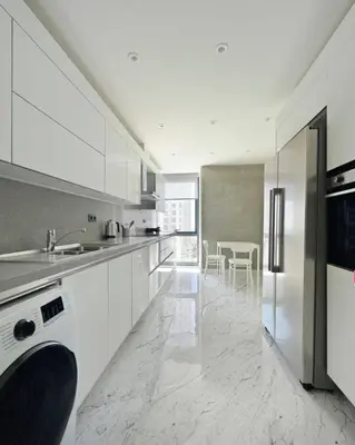 a white kitchen with a sink and a refrigerator at Cool Airy Modern 2bd2bath Parkingpoolgym! #219 in Istanbul