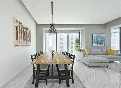 a dining room with a table and a couch at Cool Airy Modern 2bd2bath Parkingpoolgym! #219 in Istanbul