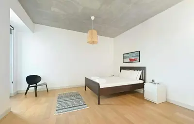 a bedroom with a bed and a chair in it at Bright Lovely Modern 2BD25 Condo PoolGym! #220 in Istanbul