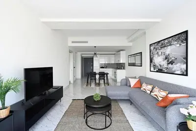 a living room with a gray couch and a tv at Beautiful Modern 1BD Condo Views w PoolGym! #223 in Istanbul