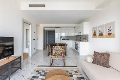 a living room with a couch and a kitchen at Gorgeous Modern 1BD Terrace CondoPoolViews! #233 in Istanbul