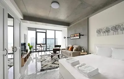 a bedroom with a white bed and a living room at Cozy Bright Studio w Parking, PoolViews! #237 in Istanbul