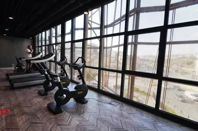 a gym with two exercise bikes in a room with windows at Cozy Bright Studio w Parking, PoolViews! #237 in Istanbul