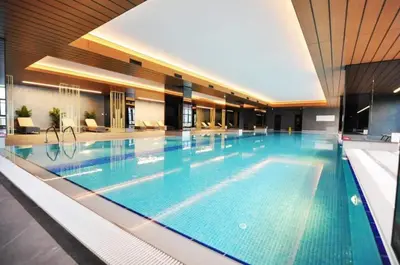 a large swimming pool in a building with a large pool at Cool Bright Studio w Parking PoolViews! #238 in Istanbul