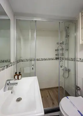 a bathroom with a shower and a sink and a toilet at Modern Prime Location 2BD1Bath Cozy Home! #213 in Istanbul