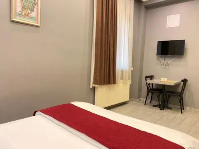 a bedroom with a bed and a table with a television at Sahrakent Otel Pendik in Istanbul