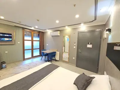 a bedroom with a bed and a table in it at Sahrakent Otel Pendik in Istanbul
