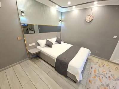 a bedroom with a bed and a clock on the wall at Sahrakent Otel Pendik in Istanbul