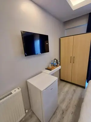 a room with a refrigerator and a tv on the wall at White Palace Haliç in Istanbul