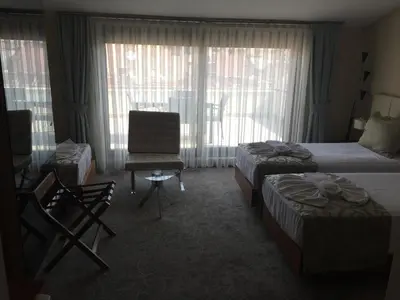 a hotel room with two beds and a chair at Inera Hotel Pendik in Istanbul