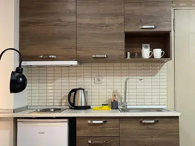 a kitchen with brown cabinets and a sink at Elegance Suites in Istanbul
