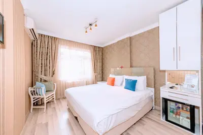 a bedroom with a large white bed and a tv at Walnut Shell Hotel in Istanbul