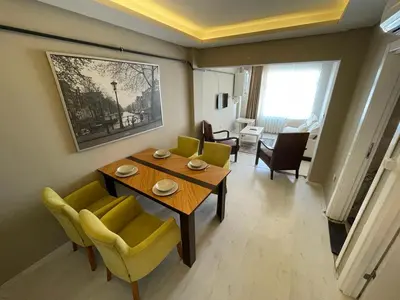 a living room with a table and yellow chairs at Golden Gate Hotel Topkapı in Istanbul