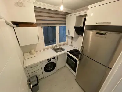 a small kitchen with a refrigerator and a sink at Golden Gate Hotel Topkapı in Istanbul