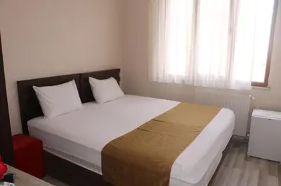a bedroom with a large bed with white sheets and white pillows at Birlik Apart Hotel in Istanbul