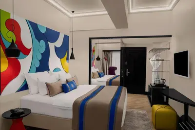 a bedroom with two beds and a painting on the wall at Sura Hagia Sophia Hotel in Istanbul