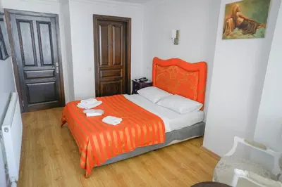 a bedroom with a bed with an orange blanket at My Way Tera Butik Otel in Adalar