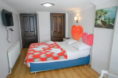 a bedroom with a bed with a red and white blanket at My Way Tera Butik Otel in Adalar