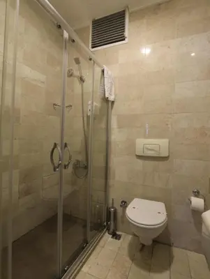 a bathroom with a toilet and a glass shower at Nil Hotel İstanbul City Center in Istanbul